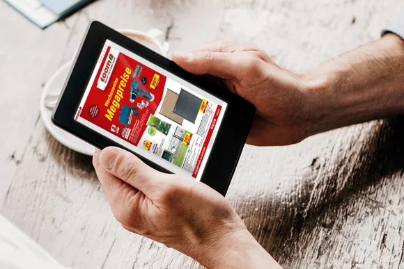 Eine Person schaut sich einen Online-Prospekt eines Baumarktes auf einem Tablet an.